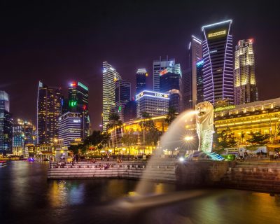 Dazzling view of the Singapore cityscape with Merlion and illuminated skyscrapers at night.